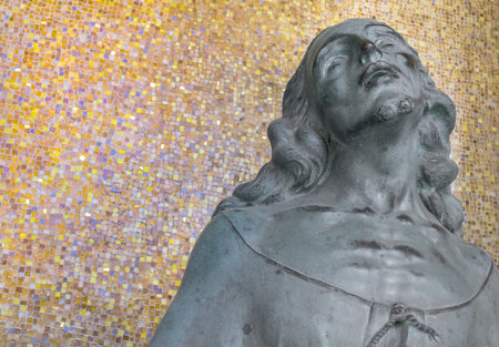 Statue of Jesus Christ against a wall mosaic