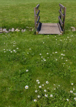 Old wooden bridge in the park, with small stream.の写真素材