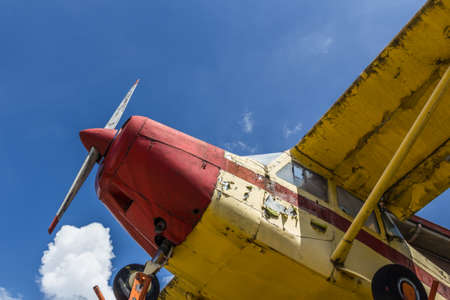 Vintage airplane seen from below, with blue sky in the backgroundの写真素材