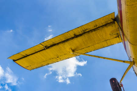 Vintage airplane seen from below, with blue sky in the backgroundの写真素材