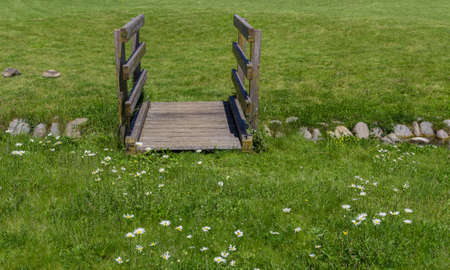 Old wooden bridge in the park, with small stream.の写真素材