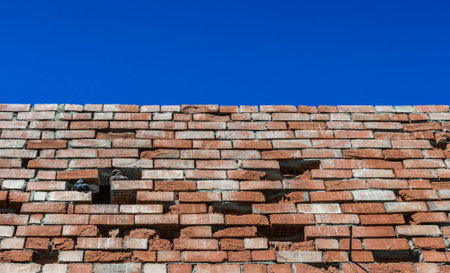 Old brick wall against bright skyの写真素材