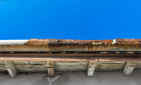 A broken gutter on the roof of a houseの写真素材