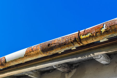 A broken gutter on the roof of a houseの写真素材