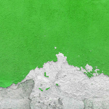 Fragment of wall with broken stucco. Old green wall with damaged shabby color plaster. Distressed wall background. Concept of renewal, of restore and repair.の写真素材
