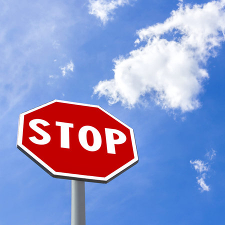 Stop sign against blue cloudy skyの写真素材