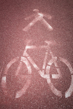 White painted sign, on red background, indicating bicycle and pedestrian lanes.の写真素材