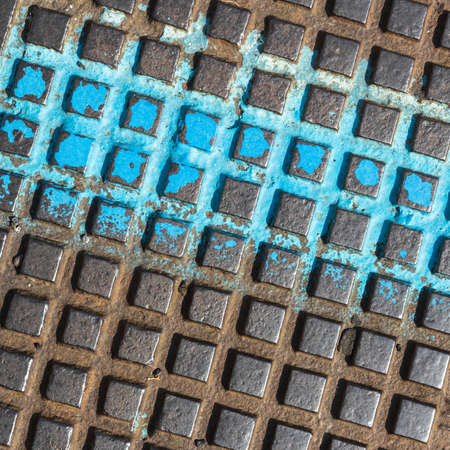 Close - up of a brown and blue manhole cover. Grunge metal background .の写真素材