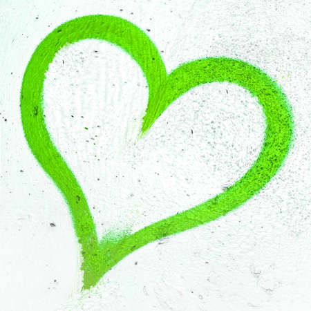 Concept or conceptual painted green abstract heart shape love symbol, dirty wall background, metaphor to urban and romantic valentine, grungy style.の写真素材