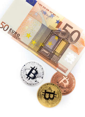 Financial concept with image of bitcoins on fifty euro banknote. Traditional money versus cryptocurrency concept.の写真素材