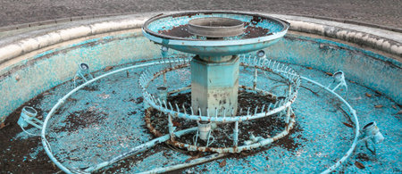 Rusty old water nozzles and illumination lamps. Abandoned equipment in empty fountain.