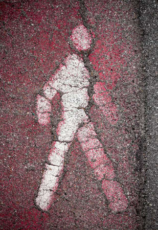 White pedestrian signal of person on asphalt, walkway pedestrian. Information and security. Faded red pedestrian stripes.の写真素材
