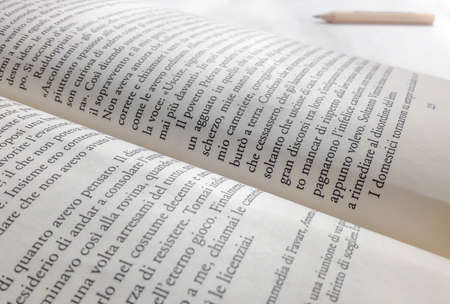 Close-up of a opened book, ready to be read and tell a story. Near, a wooden pencil. Ideal for concepts. Shallow depth of field.の写真素材