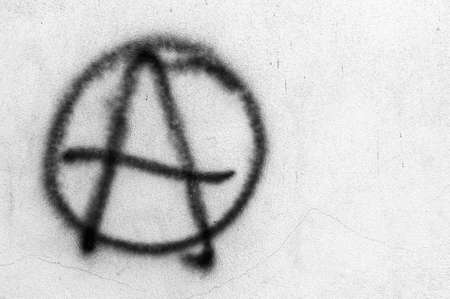 Symbol of Anarchy painted on a gray concrete wall. Ideal for concepts and backgrounds. Space for text.の写真素材