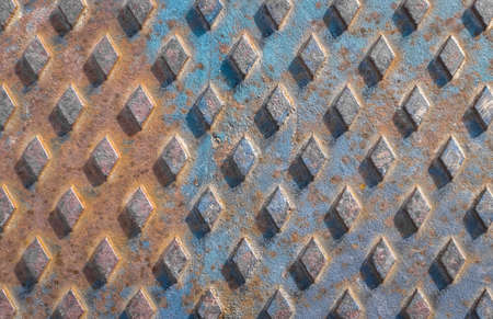 Old rusty drain cover background with diamond pattern.の写真素材