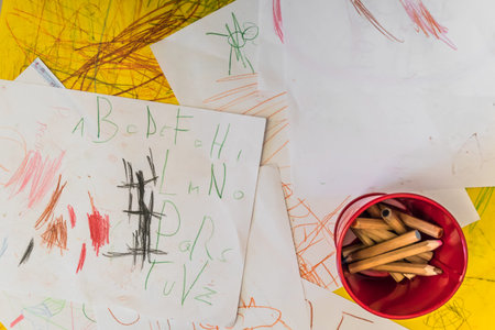 Painted sheet of paper and supplies for drawing. Top view of the child's workspace for artwork.
