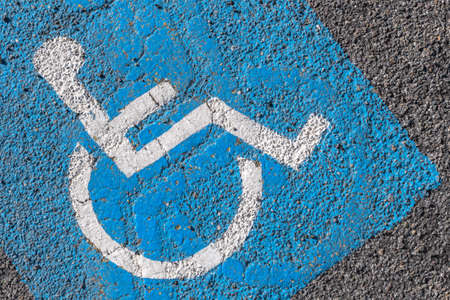 Close - up of disabled parking sign painted on tarmac. Ideal for concepts and backgrounds.の写真素材