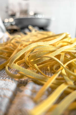 Freshly prepared Tagliatelle pasta closeup. Pasta fettuccine with wheat. Selective Focus. Defocused blurry background.の写真素材