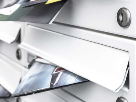 Business and advertising concepts. Modern mailboxes filled with flyers. Close-up. Shallow DOF.の写真素材