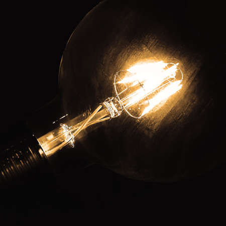 Incandescent light bulb. Vintage bulb on the dark background. Ideas and vintage concept.の写真素材