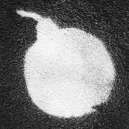 Bomb painted with white paint spray on a black wall.の写真素材