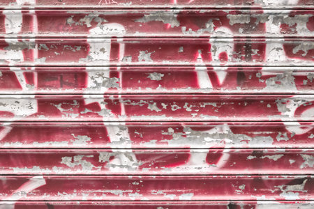 Red metal shutter with peeling paint. Ideal use for background / wallpaper.