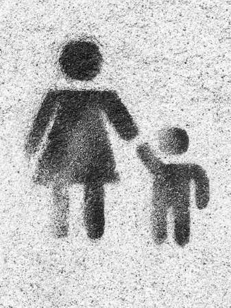 Family symbol. Mother and son are kept each other's hands. Love. Graffiti on wall as background.の写真素材