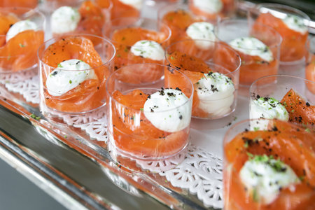 Glasses filled topped with smoked salmon and cream cheese served as appetizer for a party or an...