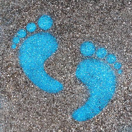 Blue footprint signs on an asphalt road for pedestrian. Symbol of walkway.の写真素材