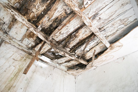 Old wooden ceiling with beams on wooden background. Needs renovation.の写真素材
