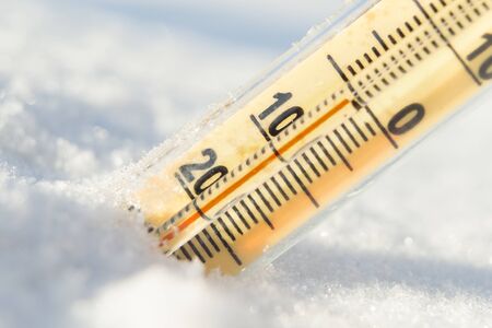 Thermometer on snow shows low temperatures in celsius.の写真素材