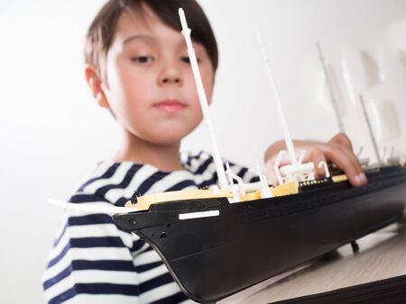 a little boy builds a model ship.の写真素材