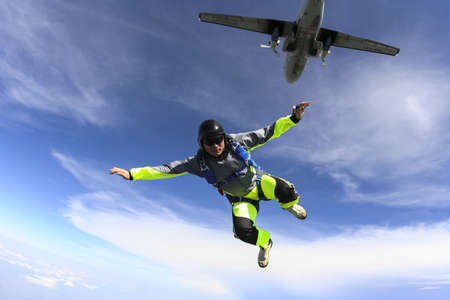 The guy parachutist jumps out of an airplane の写真素材