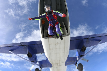 The girl parachutist jumps out of an airplane 