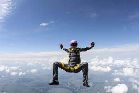 The girl parachutist performs figure freestyle in freefall.の写真素材