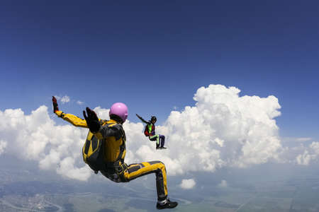 Two girls parachutists perform freestyle figures in free fall の写真素材