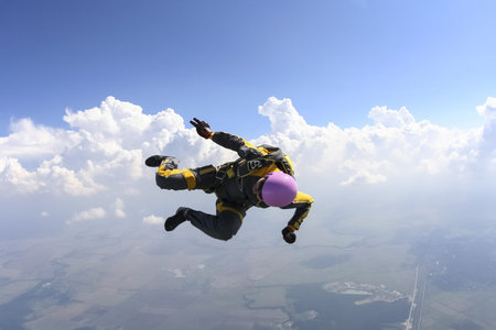The girl parachutist performs figure freestyle in freefall 