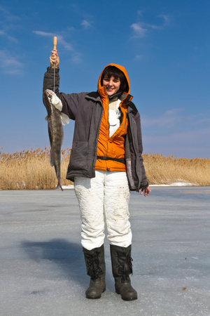 A woman with a catch after ice fishing 