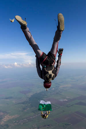 A girl and a guy skydivers perform pieces in free fall.の写真素材