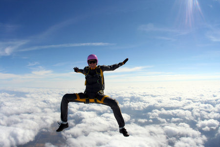 The girl parachutist performs figure freestyle in freefall 