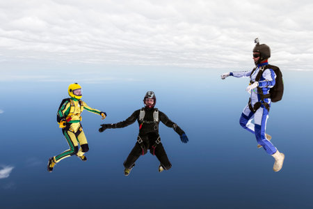 Three sports parachutist build a figure in free fall の写真素材