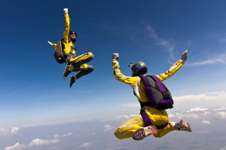 Two parachutists girls in free fall in the clouds.の写真素材