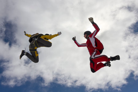 Two parachutists girls in free fall in the clouds 