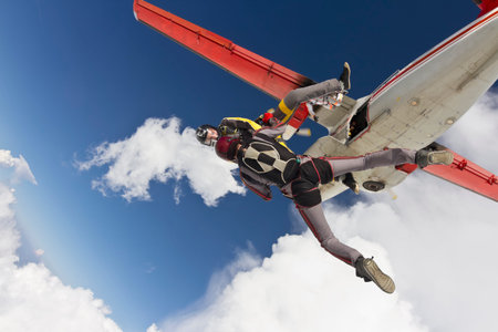 Three parachutists jumping out of an airplane in free style 