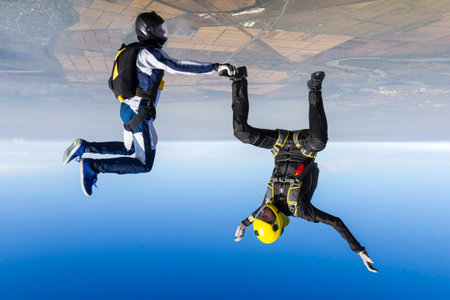 A girl and a guy skydivers perform pieces in free fall.の写真素材