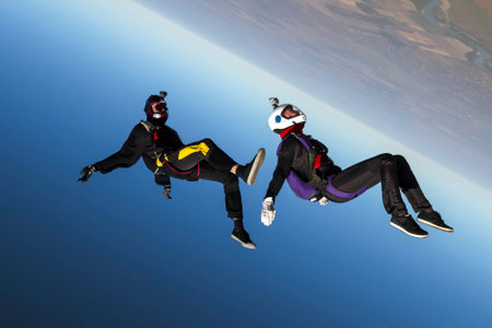 A girl and a guy skydivers perform pieces in free fall.の写真素材