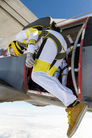 The girl parachutist jumps out of an airplane.の写真素材
