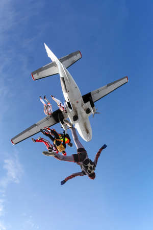 A group of skydivers jumping out of an airplane in free style.の写真素材