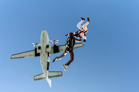 A group of paratroopers jumping out of an airplane.