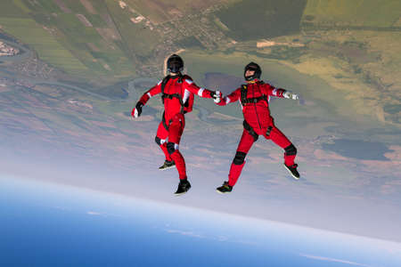 Two sports parachutist build a figure in free fall. Extreme sport concept.の写真素材